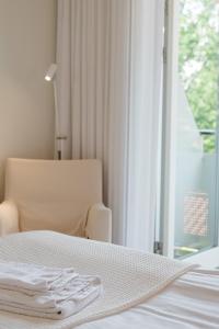 奇维克希维克酒店的一张带椅子的白色床和一个窗户