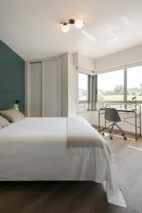 拉科鲁尼亚如是旅行公寓酒店的卧室配有一张白色大床和一张书桌