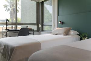 拉科鲁尼亚如是旅行公寓酒店的配有书桌和窗户的客房内的两张床