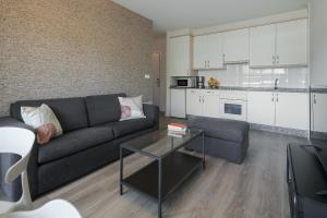 拉科鲁尼亚如是旅行公寓酒店的带沙发和桌子的客厅以及厨房。