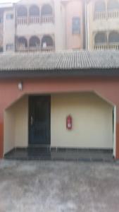 拉各斯Chinaka guest house的一座带车库的建筑,设有大门