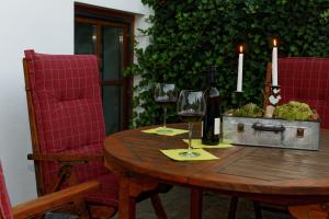 Neukirchen bei Sulzbach-RosenbergFerienwohnung Peuker的一张木桌,上面放着两杯葡萄酒和两根蜡烛