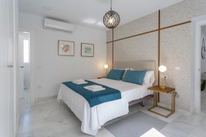 加的斯Apartamentos La BRUJULA by CadizRentals的一间卧室配有一张带蓝色枕头的大床