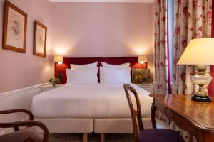 巴黎圣格力格奥尔酒店的酒店客房配有一张床、一张书桌和一张书桌。