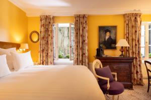 巴黎圣格力格奥尔酒店的一间卧室配有一张床、一张书桌和窗户。