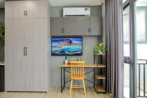 Bến LứcCherry Hotel Bến Lức的厨房配有桌子,墙上配有电视