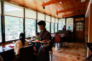 廷布Phuntsho Khangsar Hotel的坐在餐桌上吃一盘饭的人