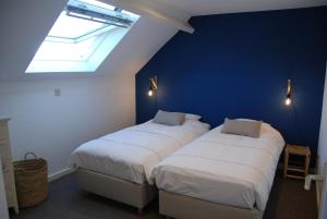 BeerselThe Little House的蓝色墙壁客房的两张床