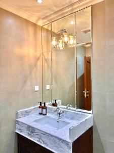 沙迦AL JUNAIDI FARM BY BRIDGE RETREATS的一间带大理石水槽和镜子的浴室