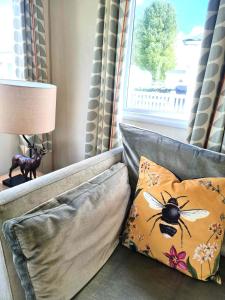 赛伦塞斯特Eden Breaks, Mallard Lake的一张带枕头的沙发,上面有蜜蜂