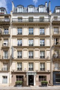 巴黎圣格力格奥尔酒店的大型米色建筑,设有窗户和阳台
