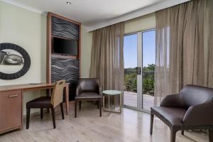 乌平通阿平顿万豪Protea酒店的酒店客房设有一张桌子、椅子和大窗户。