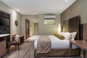 乌平通阿平顿万豪Protea酒店的酒店客房设有一张大床和一张书桌。