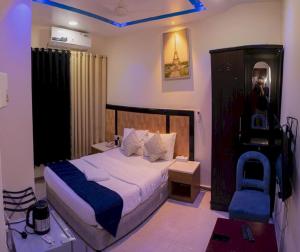 沙迦Sharjah Plaza Hotel的一间卧室配有一张床、一张桌子和一把椅子