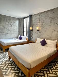 普吉镇纳暹罗旅馆的紫色枕头间内的两张床