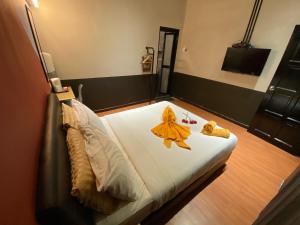伯恩仓Kavy Boutique Hotel @ KBH的一间卧室配有一张黄色浴袍的床