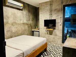 普吉镇纳暹罗旅馆的一间卧室配有一张床和一台平面电视