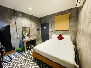 普吉镇纳暹罗旅馆的一间卧室配有一张床和一台电视。
