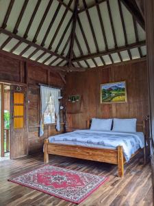 沃诺索博Le Desa Resort Syariah的木制客房内的一间卧室,配有一张床