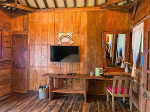 沃诺索博Le Desa Resort Syariah的客房设有木墙、书桌和镜子