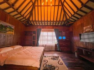 沃诺索博Le Desa Resort Syariah的一间卧室设有一张床、一台电视和一个窗口。
