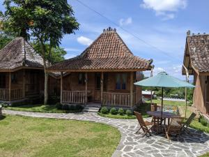 沃诺索博Le Desa Resort Syariah的房屋配有桌椅和遮阳伞