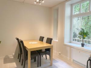 奥勒松Ålesund City Center - Modern 80-m2 flat with 3 bedrooms的一间带木桌和椅子的用餐室