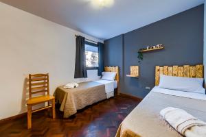 科尔多瓦Viaggiato Nueva Cordoba的客房设有两张床、一把椅子和窗户。