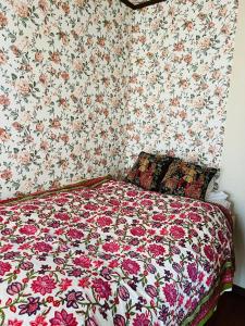 富士市Eishinan 栄進庵的一间卧室配有一张带花卉壁纸的床