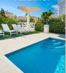 德尼亚维拉莫尔酒店的蓝色游泳池配有白色椅子和遮阳伞