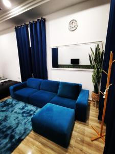 瓜拉丁加奴MINI HOTEL CONCEPT的客厅配有蓝色的沙发和时钟