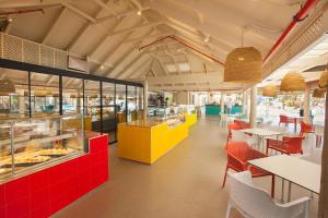 英格兰海滩阿博拉欧陆洛普森酒店的餐厅设有红色和黄色的柜台和桌子