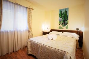 锡耶纳Hotel Arcobaleno Siena的一间卧室配有一张床,上面有两条毛巾