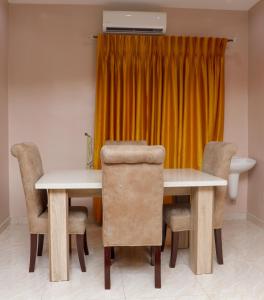 乌约E&T Luxury Apartments的一间带桌椅的用餐室