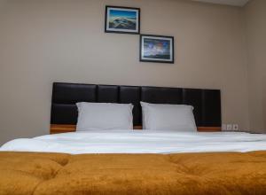 乌约E&T Luxury Apartments的一张大床,配有黑色床头板和两个枕头