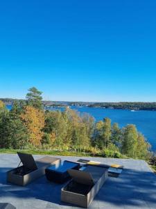 TyresöVilla Stockholms skärgård 30 min från Stockholm centralt的庭院设有2张桌子,享有湖景