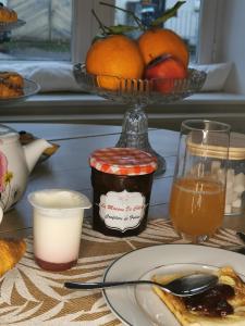 ArryLa maison de Céline的一张桌子,上面放着一盘食物和一碗橙子