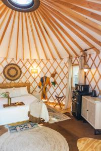 奥斯汀Camposanto Glamping - The Macaw Yurt的蒙古包内一间卧室,配有一张床