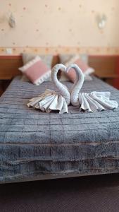 盖雷Hôtel Le Pommeil的一张带两个天鹅的毛巾床