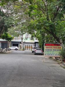 Ðông HòaKhách sạn Dạ Lan的街道中央的标志,汽车停泊