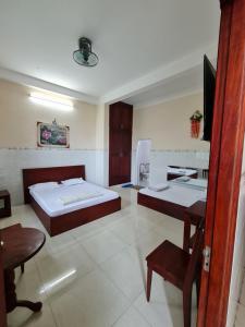 Ðông HòaKhách sạn Dạ Lan的客房设有两张床、一张桌子和电视。
