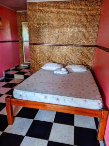 里奥普雷托达伊娃Pousada Aguiar的一张位于带 ⁇ 形地板的客房的床位