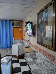 里奥普雷托达伊娃Pousada Aguiar的客房设有书桌和墙上的电视