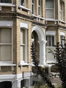 布莱顿霍夫Stunning Victorian Mansion Flat的砖砌建筑,设有拱形窗户和围栏