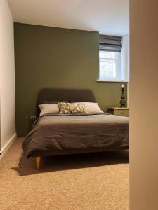 布莱顿霍夫Stunning Victorian Mansion Flat的卧室内的一张床位,卧室设有绿色的墙壁