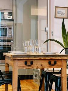 布莱顿霍夫Stunning Victorian Mansion Flat的厨房里配有带酒杯的木桌