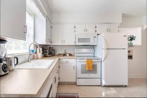 圣彼得堡In the Center of Gulfport, Min Away From the Beach!的厨房配有白色橱柜和白色冰箱。