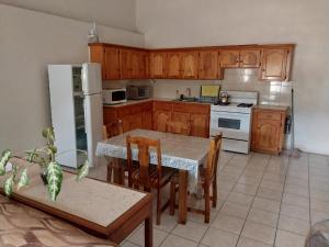 CalliaquaCasa Villa Apartments的厨房配有木制橱柜和桌椅