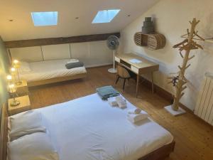 安锡L'escalier du Château T4 Duplex 9 couchages 4*的一间卧室配有两张床和一张带风扇的书桌。