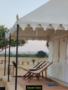 KhuriJaisalmer Safari Base & Camp的帐篷下一对躺椅